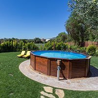 An above ground pool sets on a concrete pad